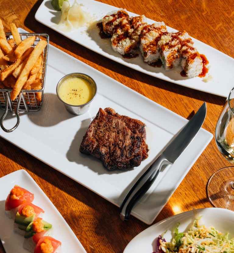 plates of steak frites and sushi