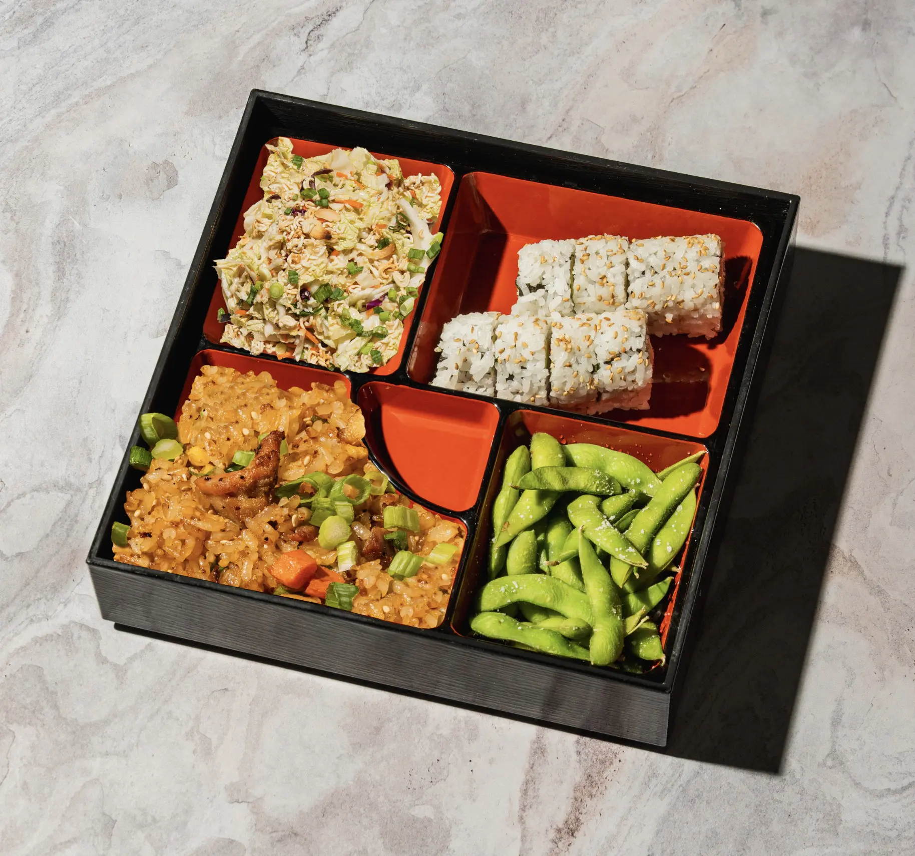 Kona Grill's Lunch Bento Box, featuring fried rice, sushi rolls, edamame and chicken.