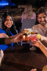 People doing a cheers with delicious Kona Grill drinks.